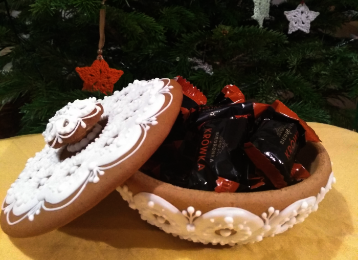 Cena pro vítěze ankety - perníková krabička ozdobená polevou ve tvaru krajky naplněná bonbóny, v pozadí vánoční stromeček