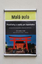 Orientační cedule s informacemi o akci a obrázkem japonské brány při vstupu do auly