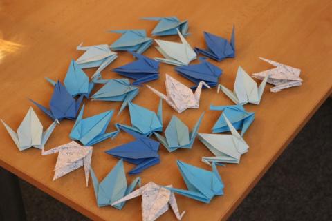 Origami jeřábi připravení pro návštěvníky akce Origami jeřábi pro návštěvníky besedy leží na stole